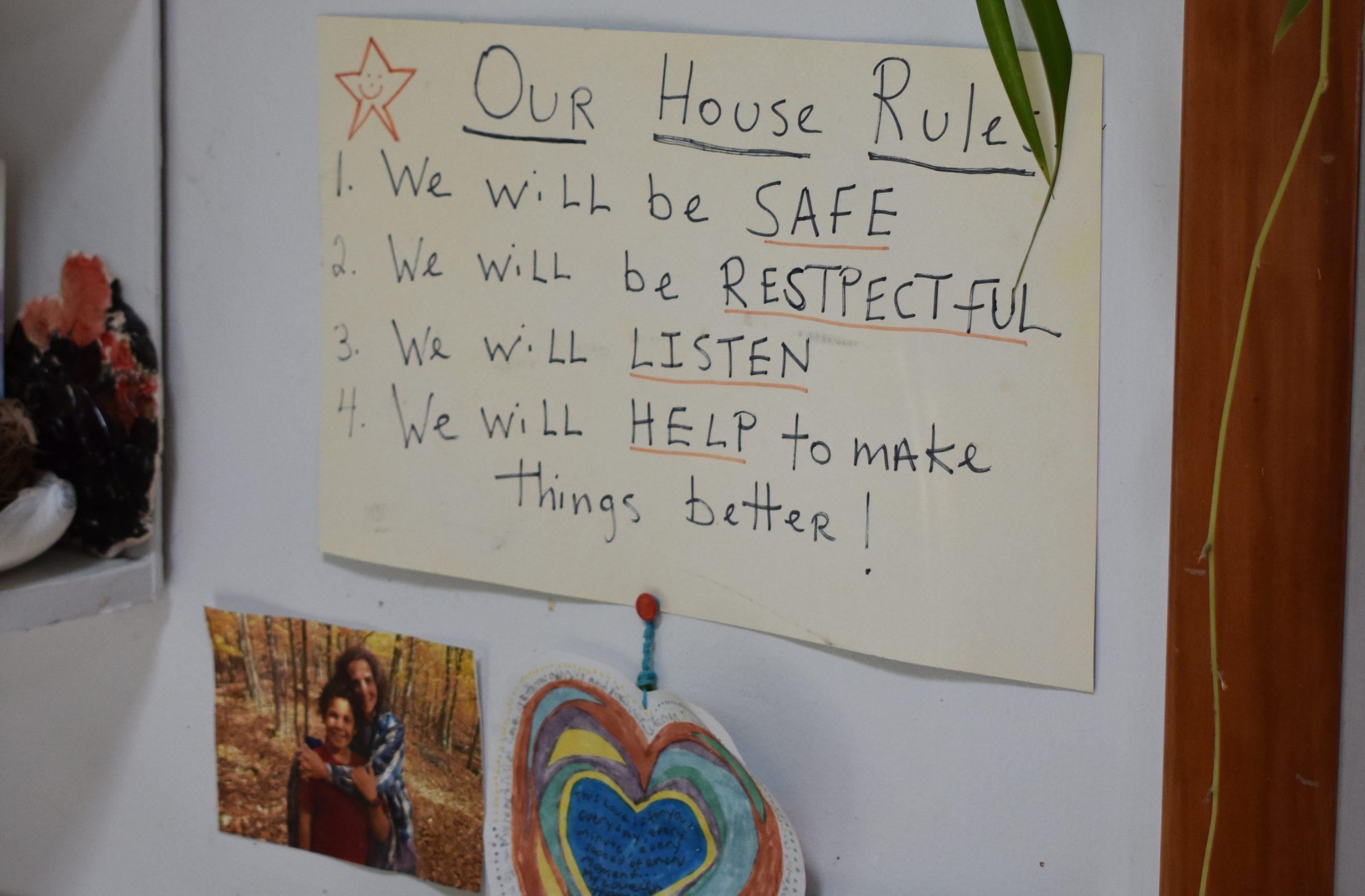Photo of handwritten sign in family's home that reads: "Our house rules: 1) We will be safe. 2) We will be respectful. 3) We will listen. 4) We will help to make things better!
