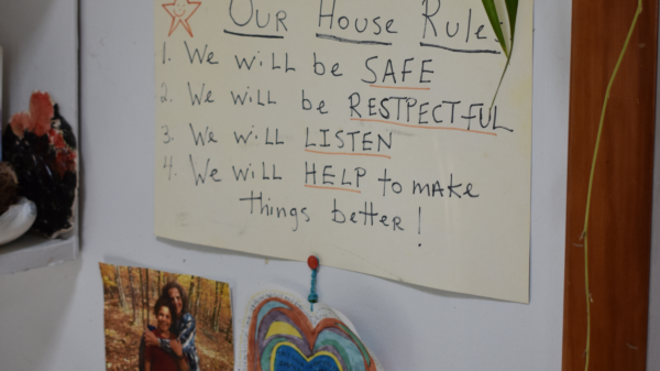 Photo of handwritten sign in family's home that reads: "Our house rules: 1) We will be safe. 2) We will be respectful. 3) We will listen. 4) We will help to make things better!
