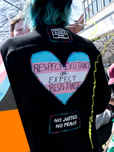 trans flag and protest signs in support of trans rights