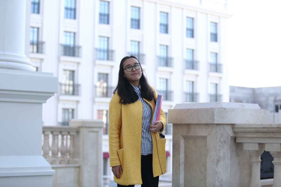 Student standing with a book