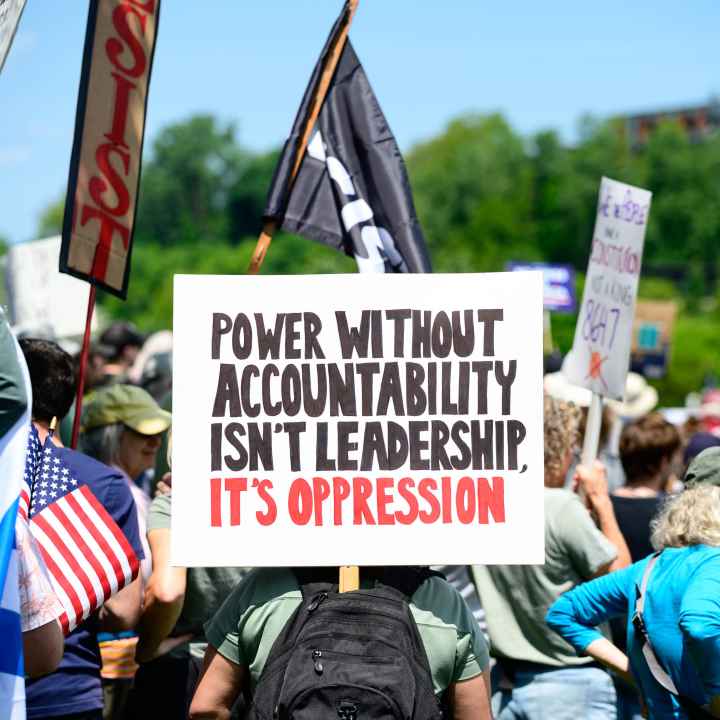 Rally crowd from No Kings Day protest, sign reads "Power without accountability isn't leadership, it's oppression"